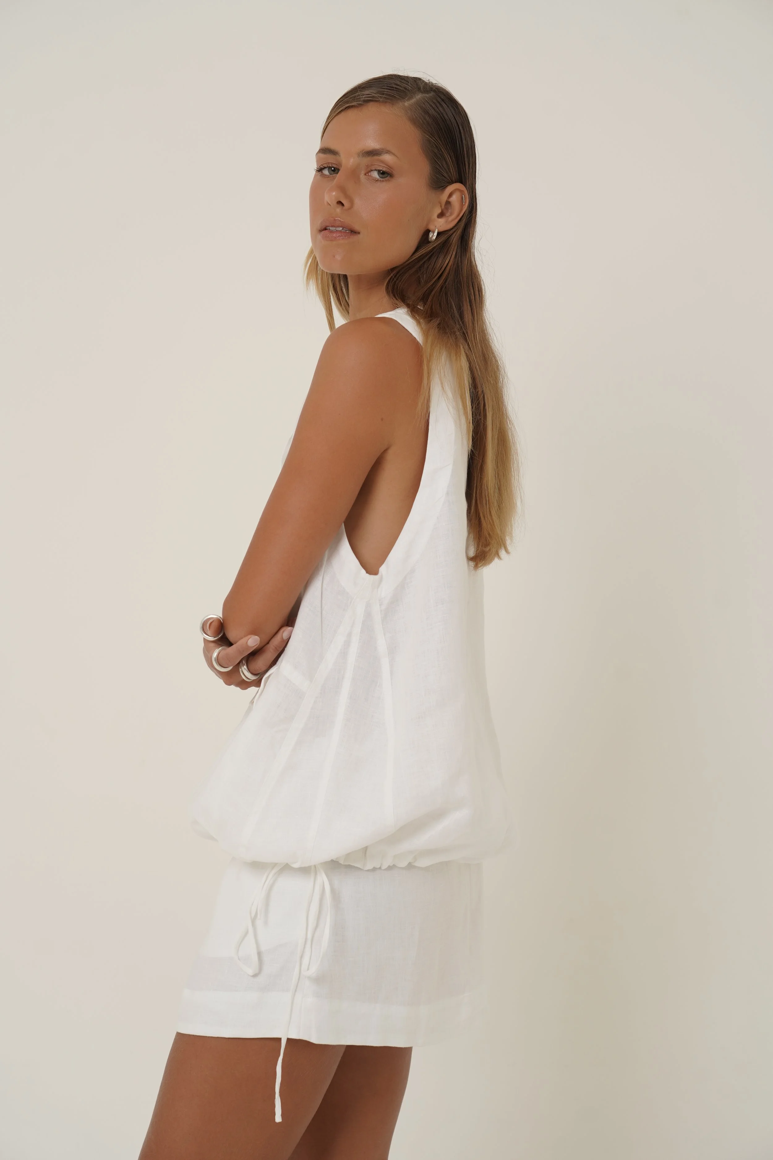 Woman wearing white linen Maribou vest with drawstring side view