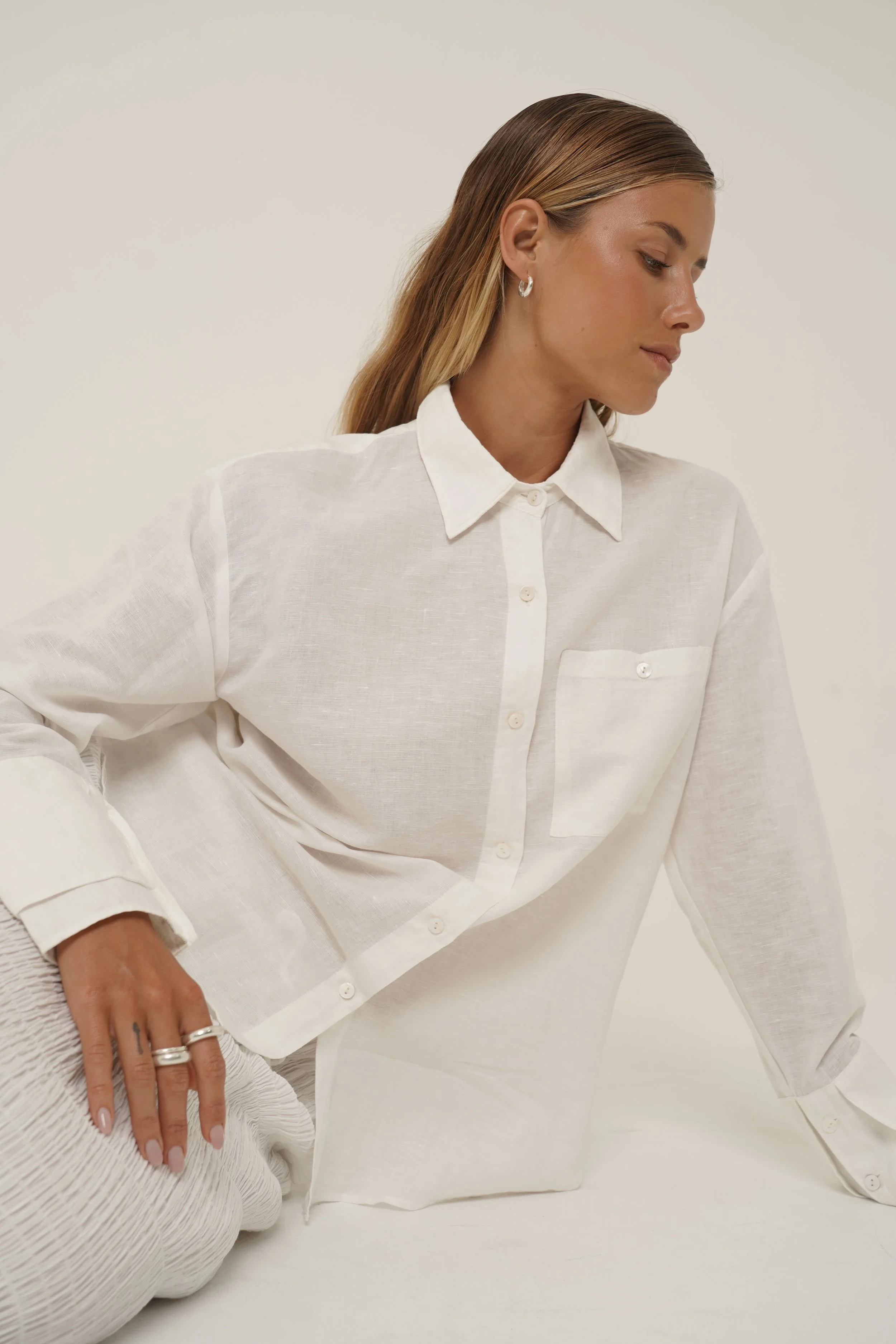 Woman wearing Reformation Shirt from Sutura Studio sitting down