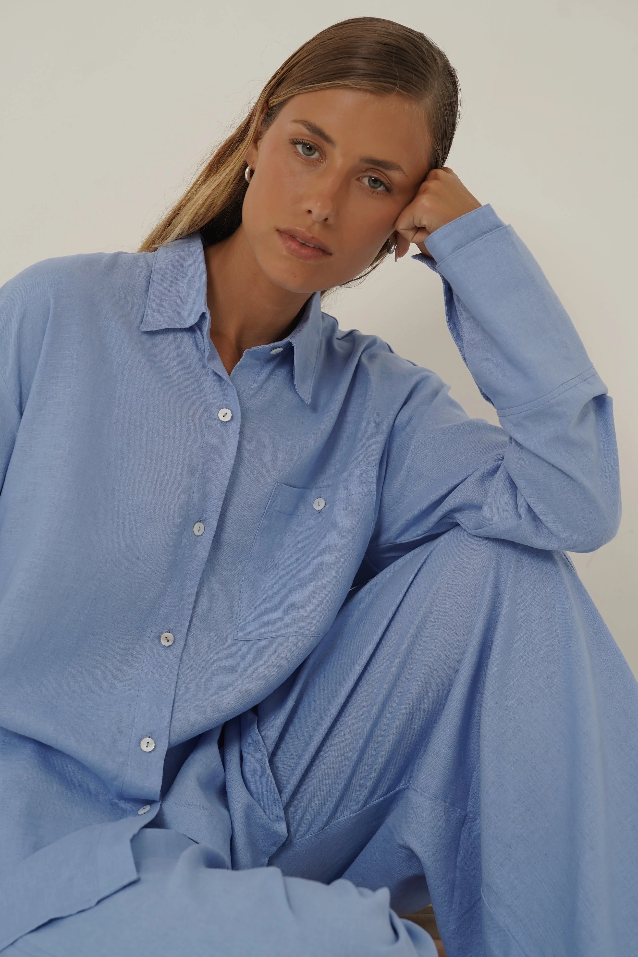 Woman wearing blue Reformation Shirt with open back and sunglasses