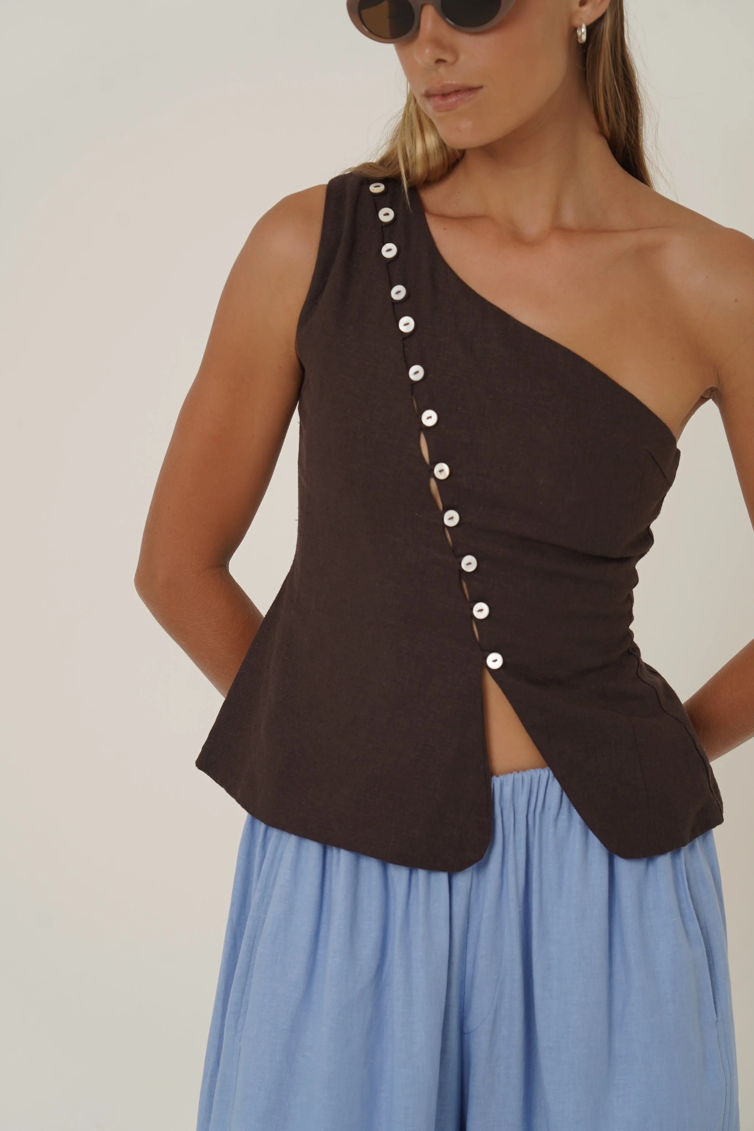 Woman looking down wearing Sriani Vest in Chocolate