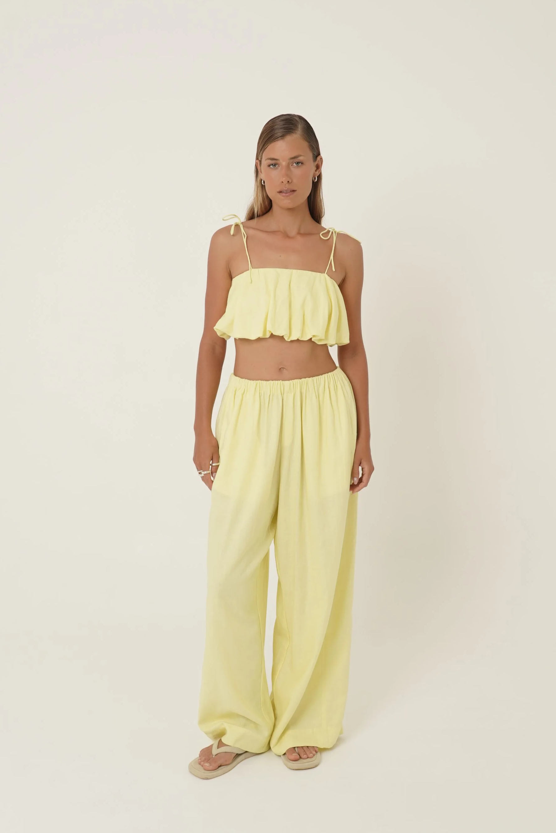 Woman wearing Crescendo Top & Bottoms in lemon colored pure linen