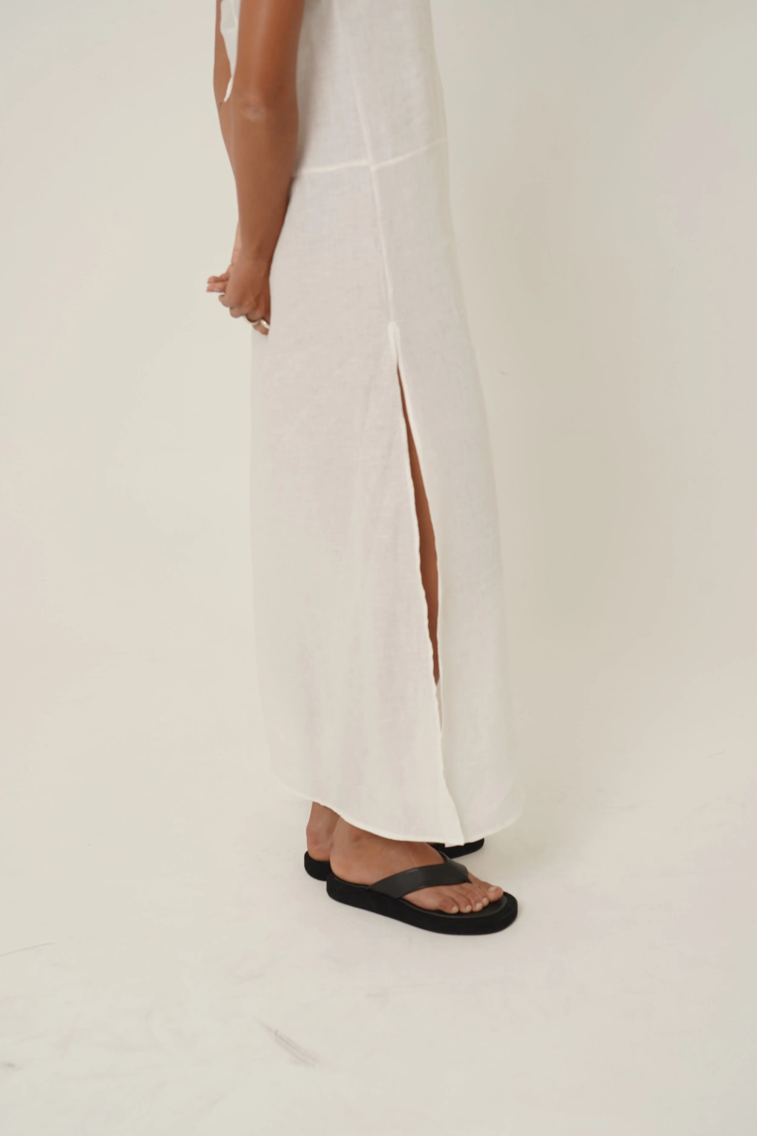 Woman wearing Prélude Maxi Dress in pure linen side view with side slit