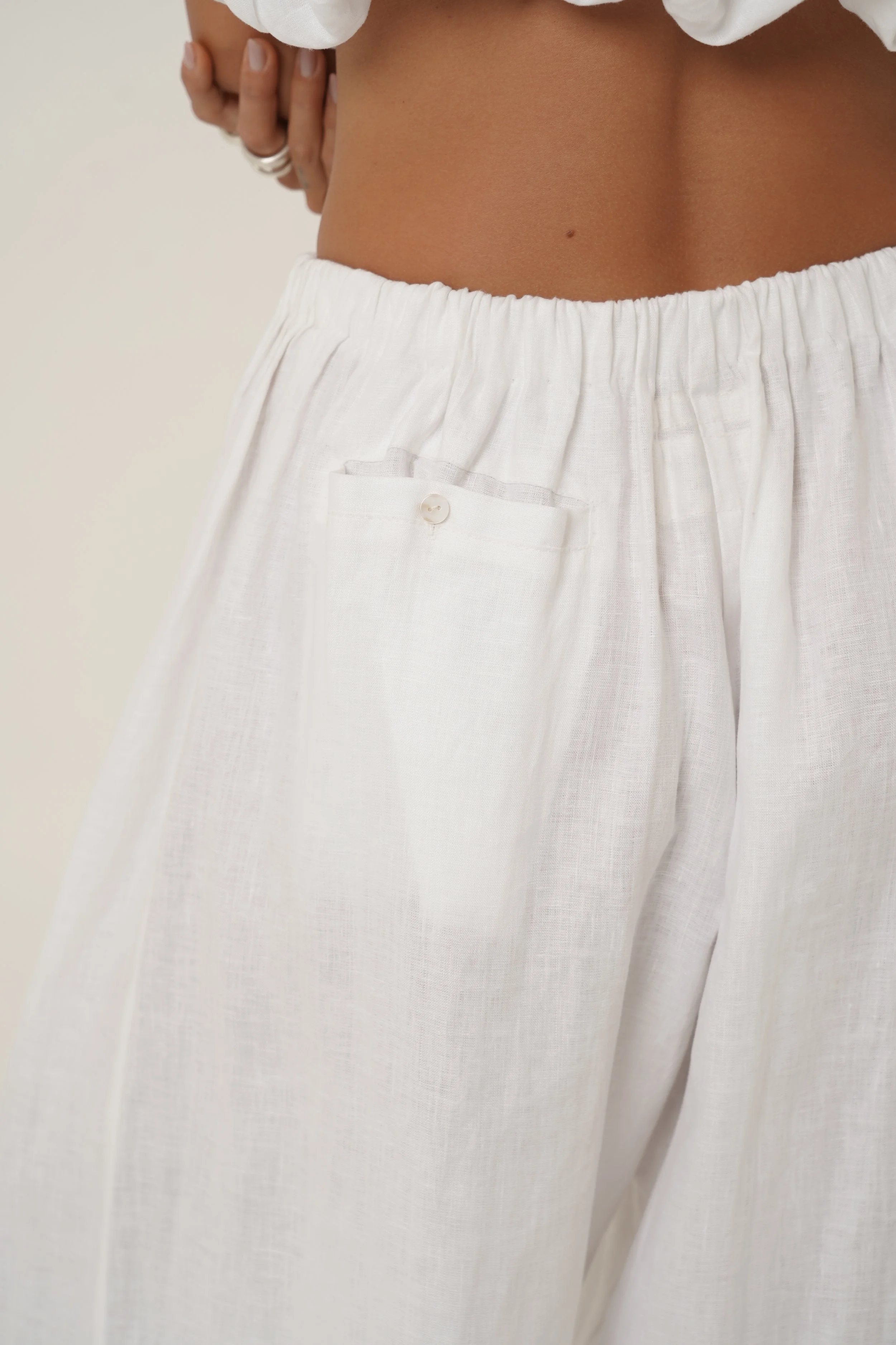 Woman wearing  white linen Crescendo Pants - back view