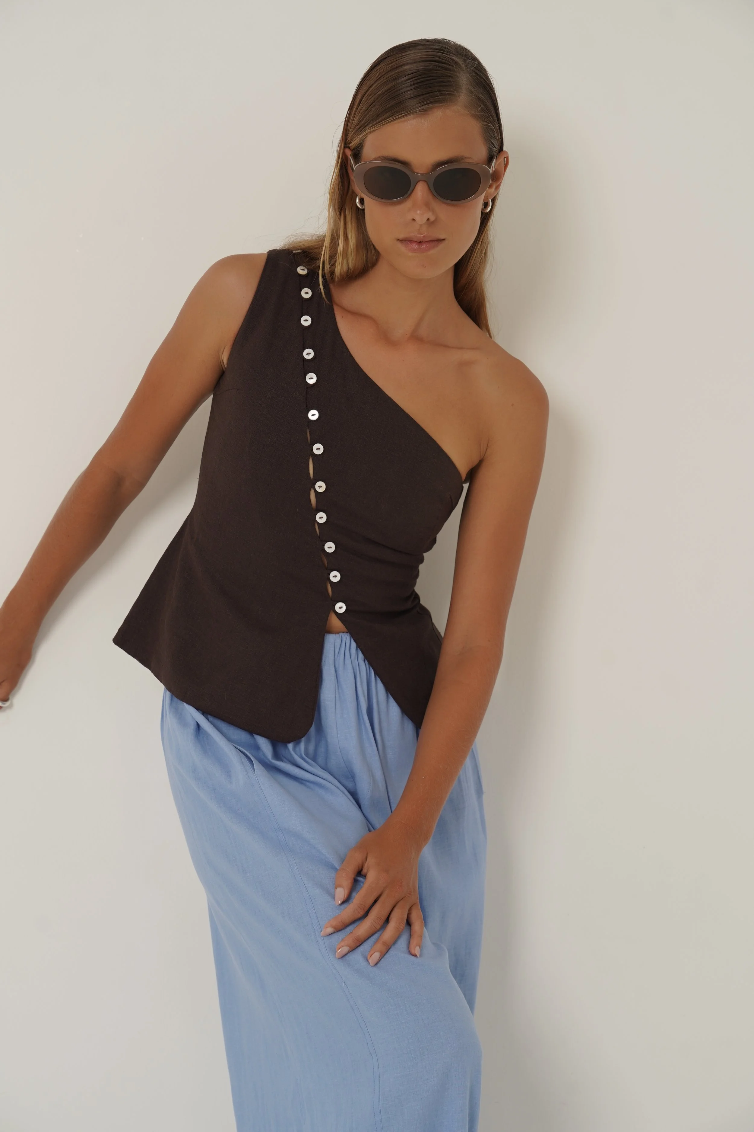 Woman leaning sideways wearing cotton linen Sriani Vest in Chocolate color