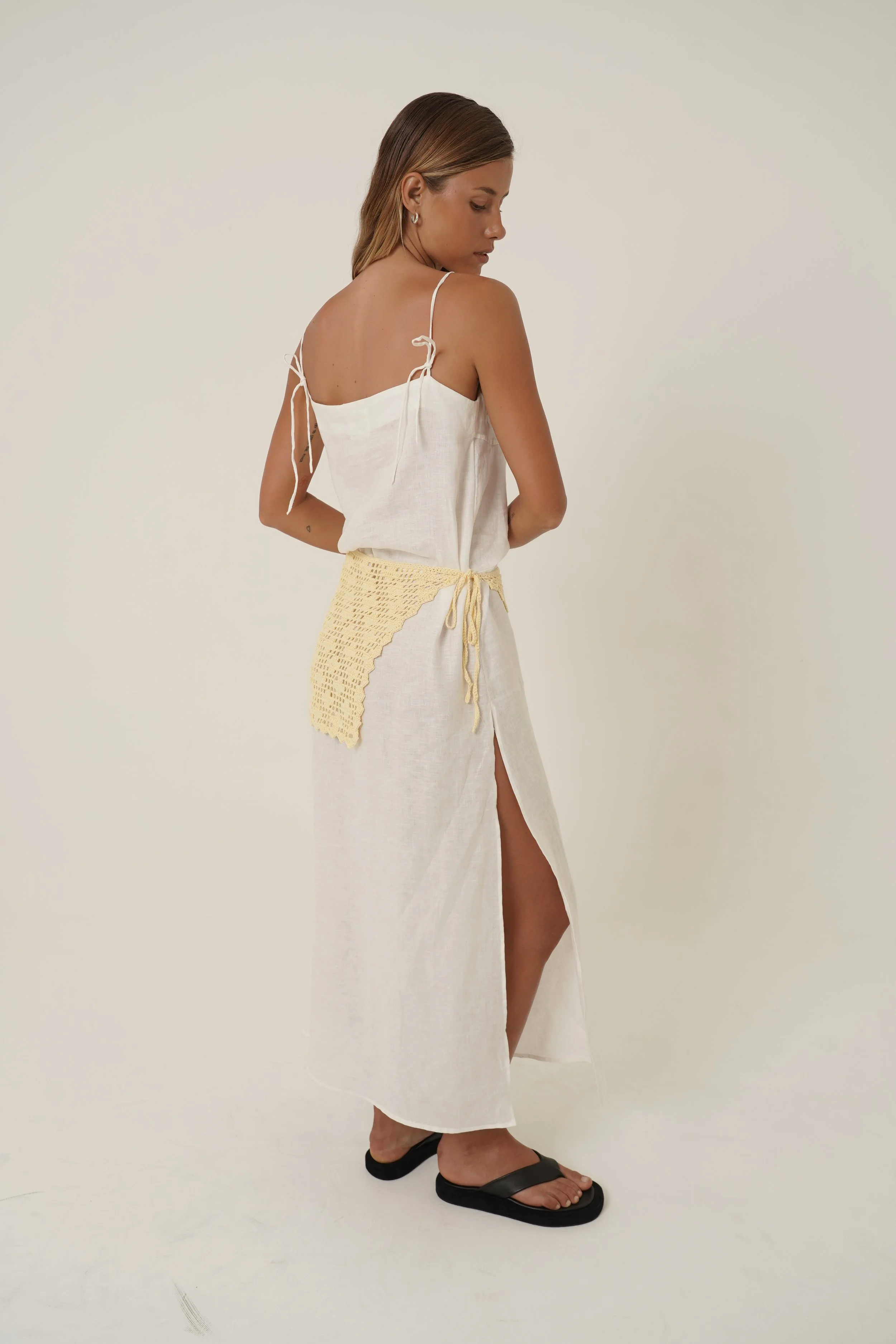 Woman wearing Prélude Maxi Dress in pure linen and Labelle Crochet Sarong side view with side slit