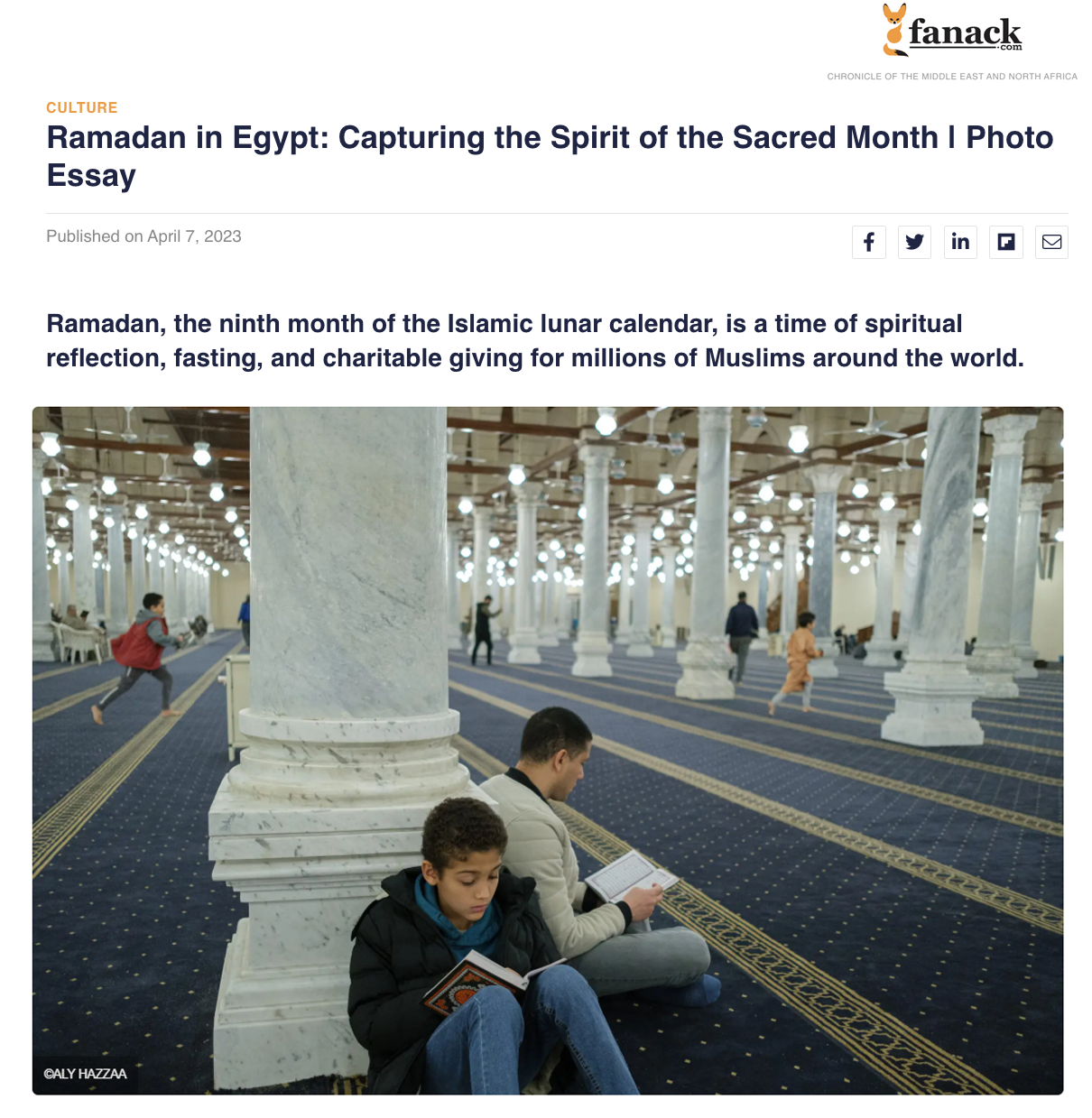 Inside a mosque, two people sit on the floor reading religious texts with a background of marble pillars and children playing.
