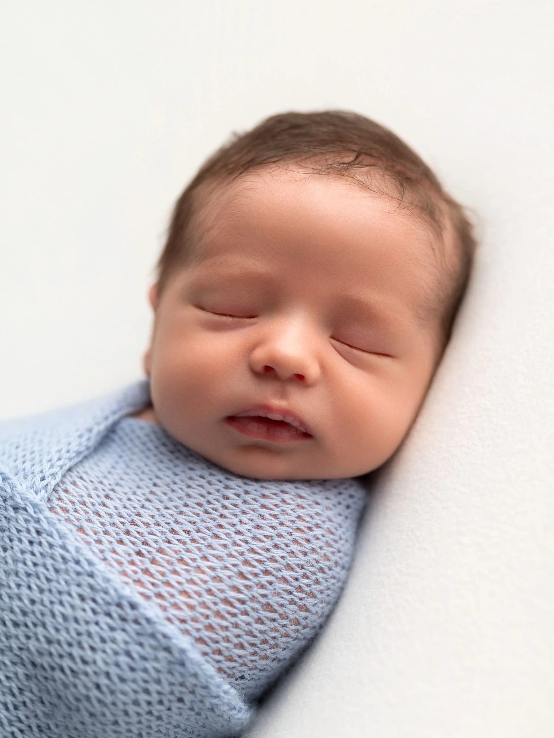 A baby asleep wrapped in a blanket
