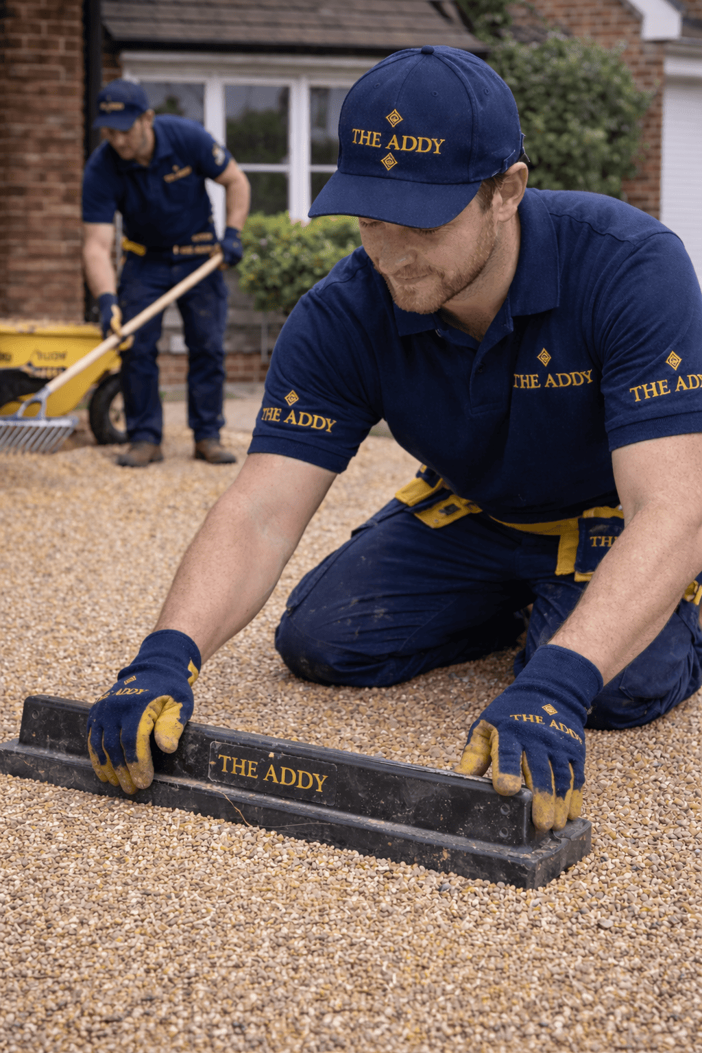 Two workers in blue uniforms with yellow accents and