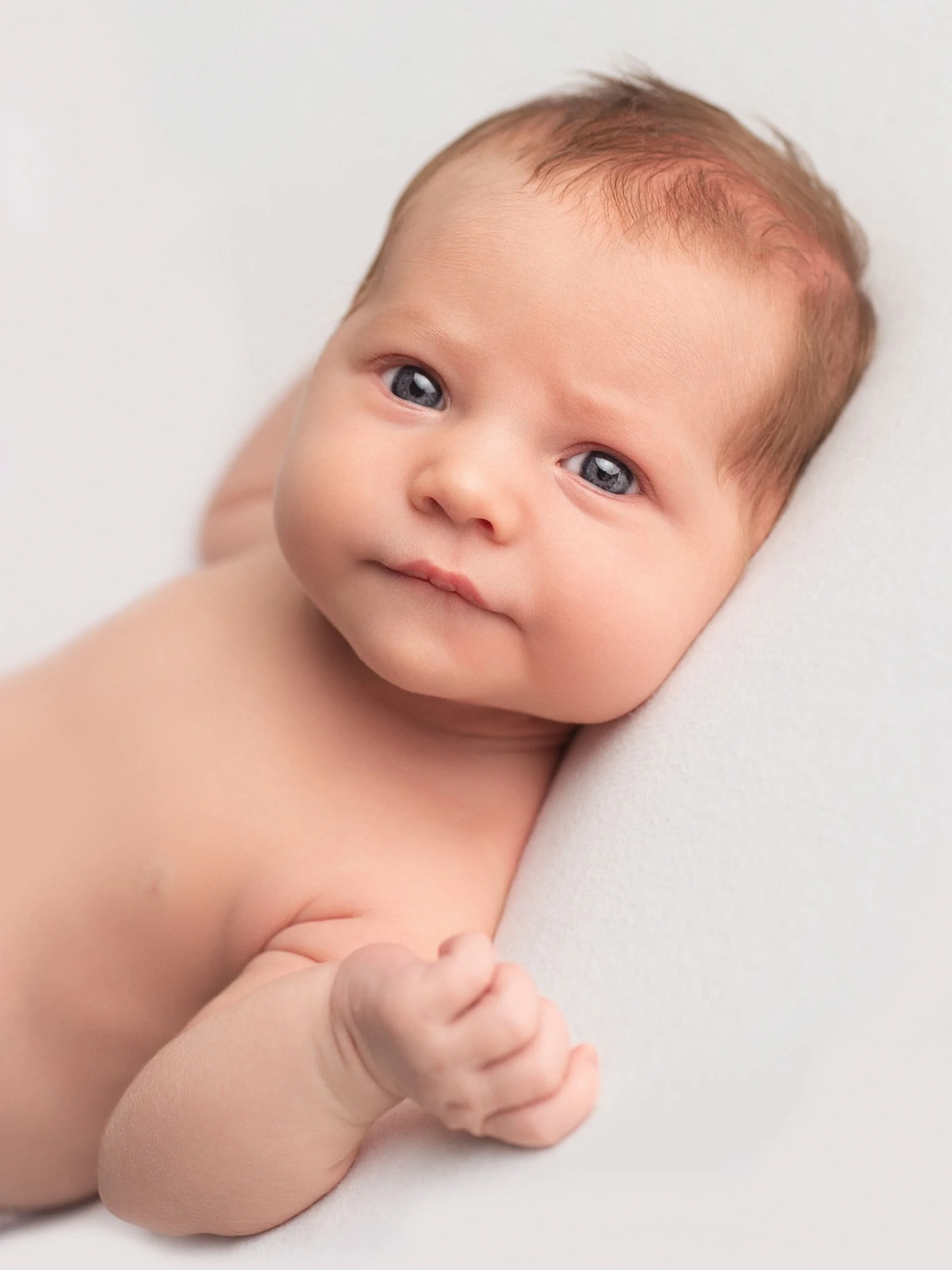A baby staring at a camera whilst their photo is being taken