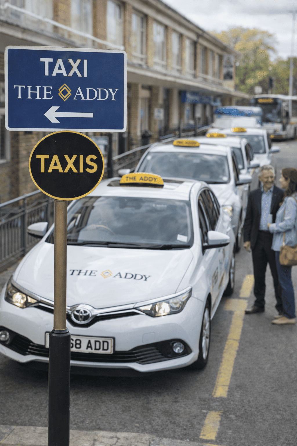 A street scene with multiple taxis parked along the sidewalk, with signage indicating a taxi stand for 'The Addy'.