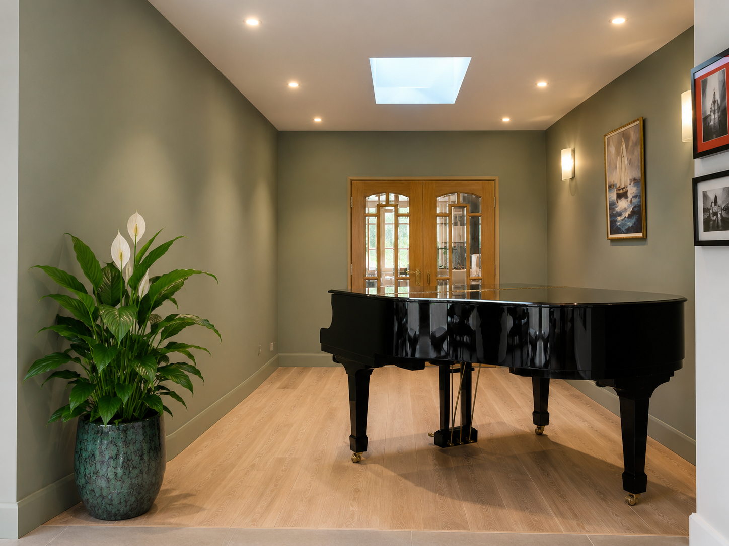 Sage green piano room with skylight, oak flooring and wall lights, designed by Baker & Fellows