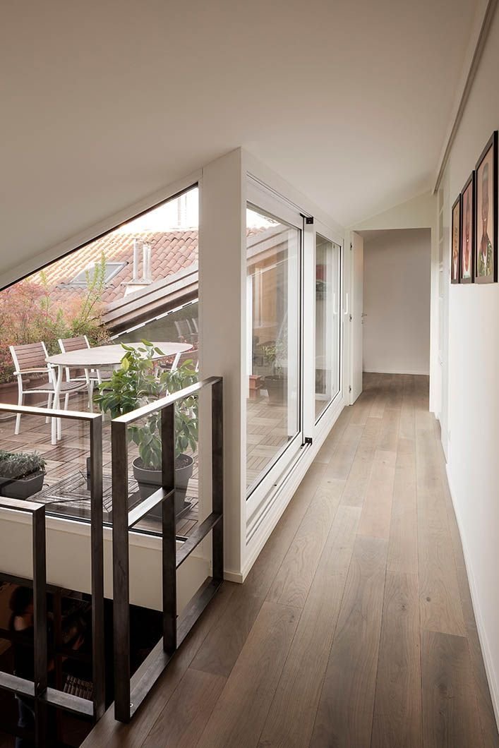 Loft hallway with glass sliding doors opening onto a roof terrace and wide-plank wood floor
