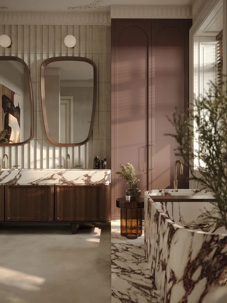 Marble bathtub with pink lacquered wardrobe doors and copper-framed mirrors