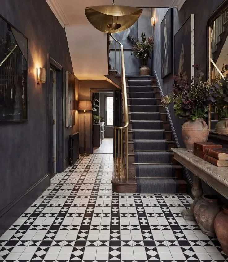 Dark painted Victorian hallway with patterned tile floor and staircase in a Kennington period home