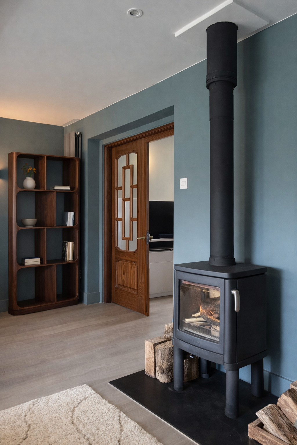 Luxury bedroom interior design in a wimbledon home featuring a woodburning stove and decreative door leaf.