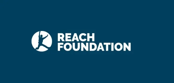 Logo of REACH FOUNDATION featuring a person reaching upward inside a circle with bold white text.