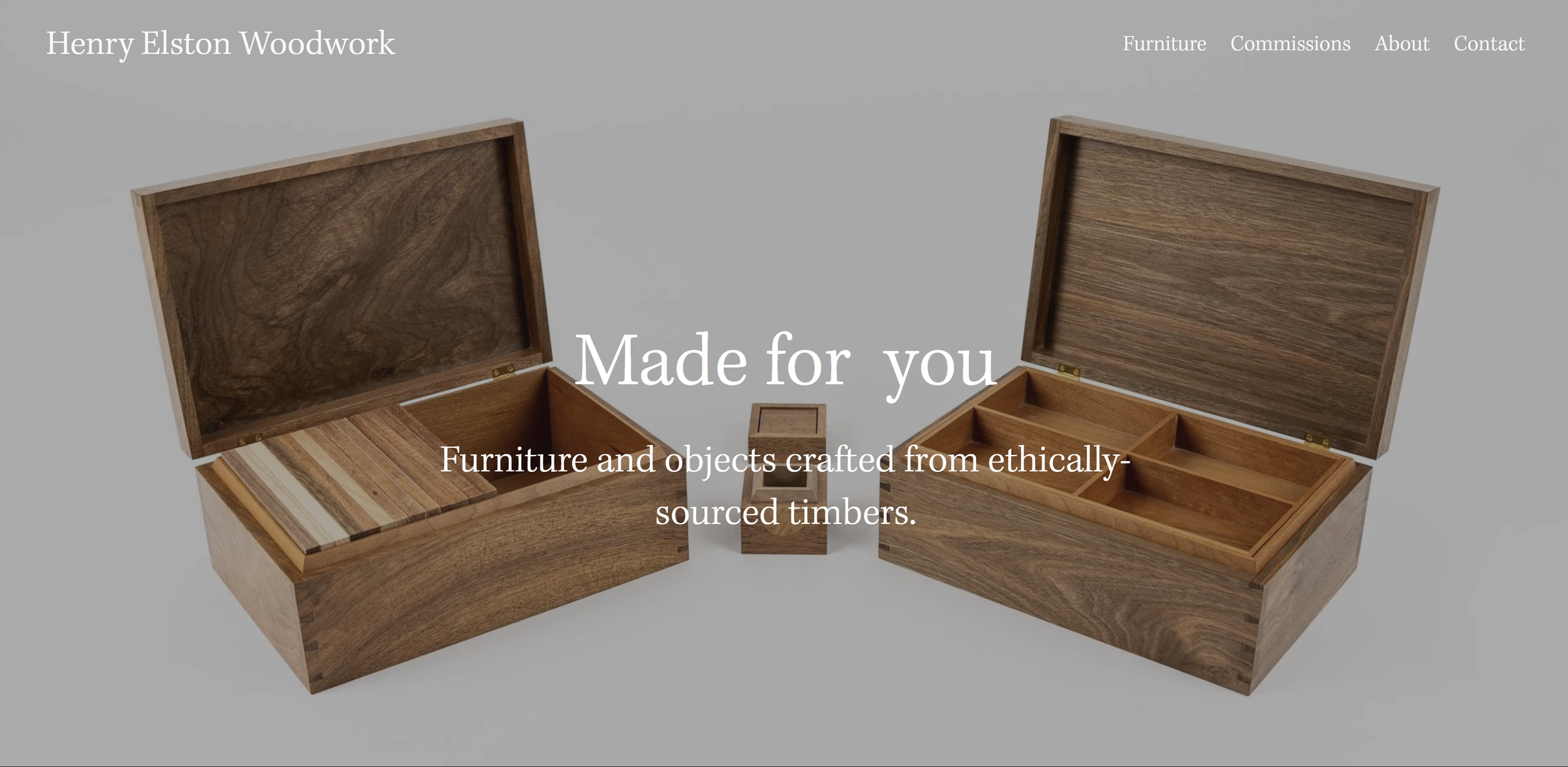 Two wooden boxes with open lids showing organized compartments and interior wood grain, on a gray background with website text overlay for Henry Elston Woodwork.