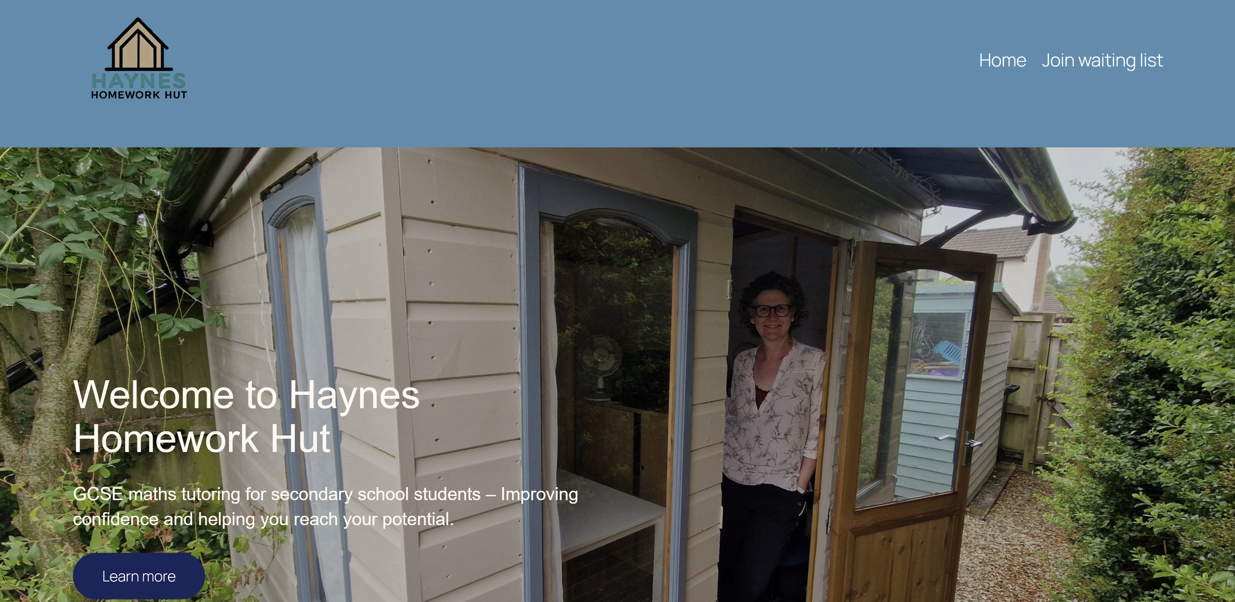Homepage of Haynes Homework Hut with a woman standing inside a small wooden building with a glass door, surrounded by greenery.