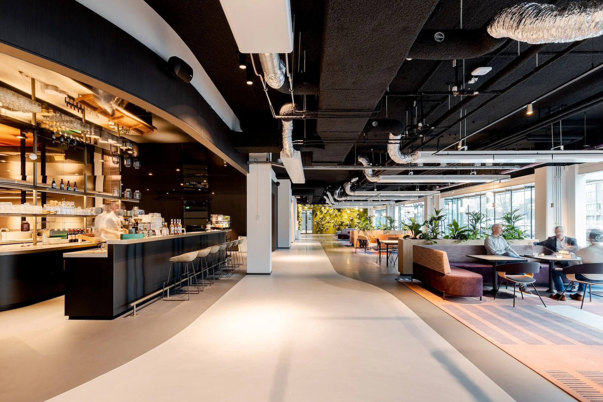 office lobby that is warm and cosy with bar, reception and cowering desks