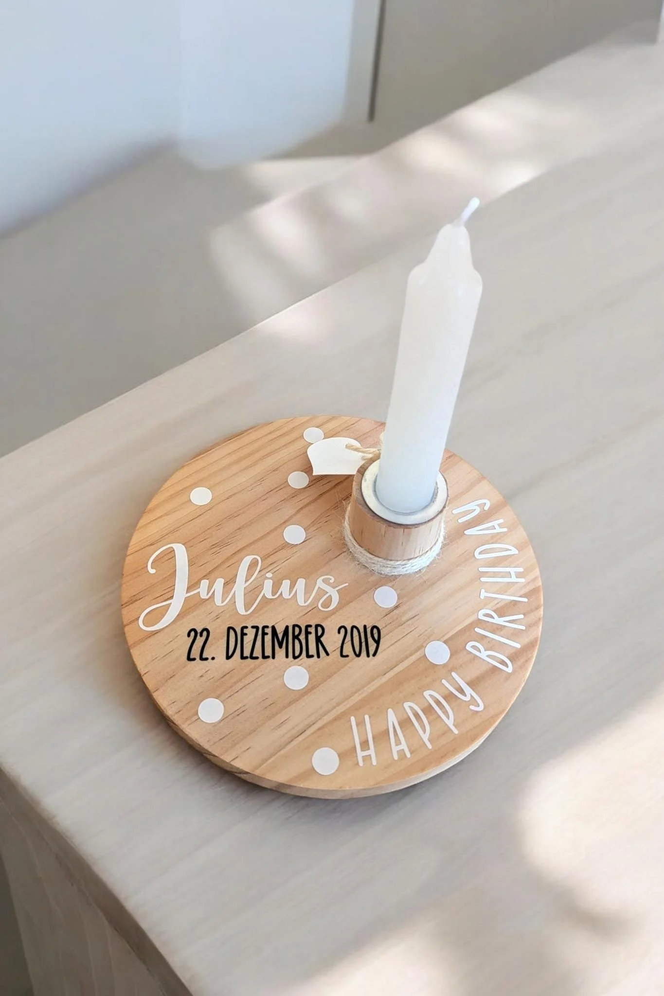 Geburtstagskarte mit Kerze, personalisiert mit Namen Julius, Datum 22. Dezember 2019, und der Nachricht "Happy Birthday" auf einem Holzuntergrund.