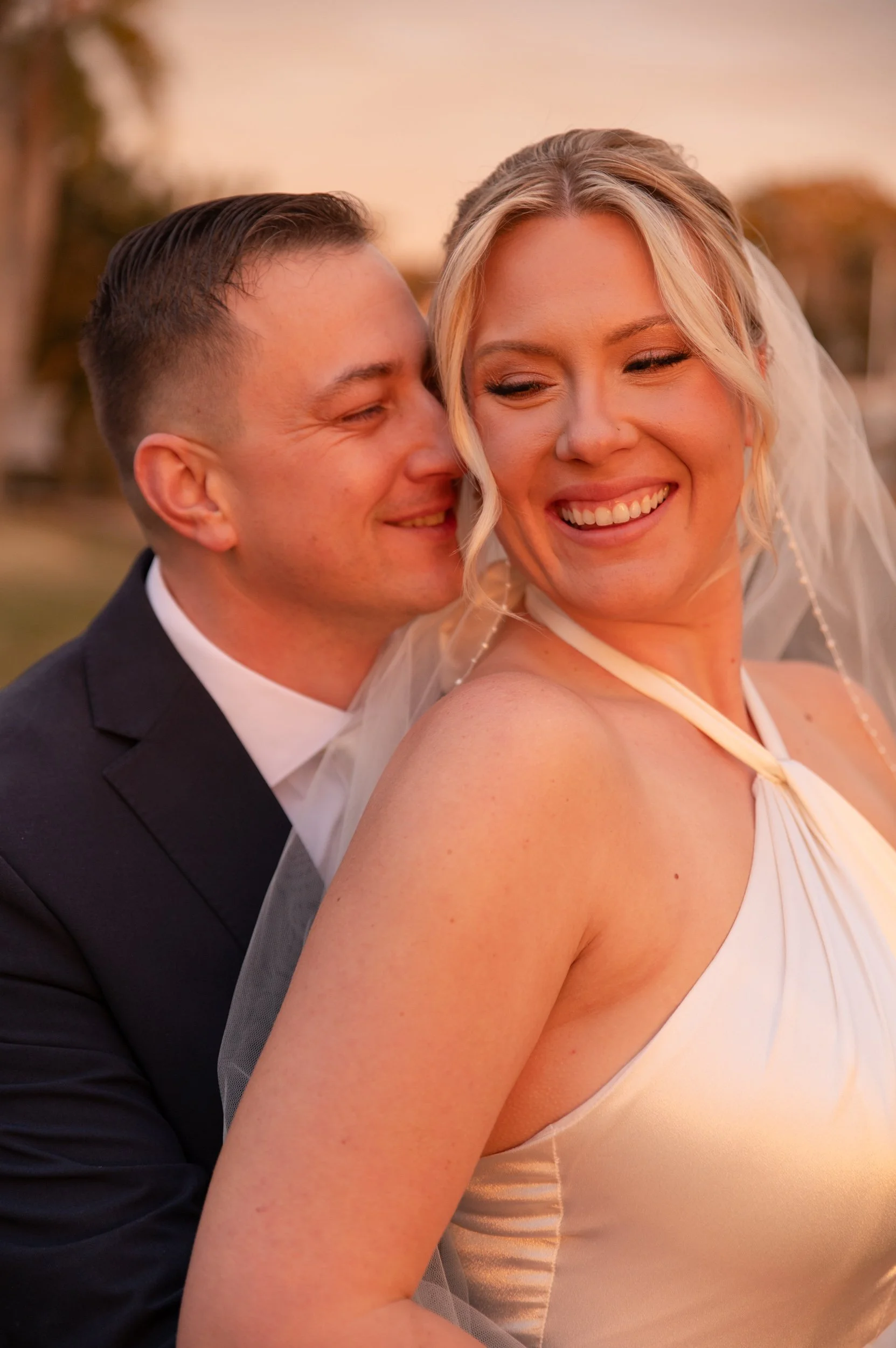 A smiling bride and groom during wedding sunset, close-up portrait.