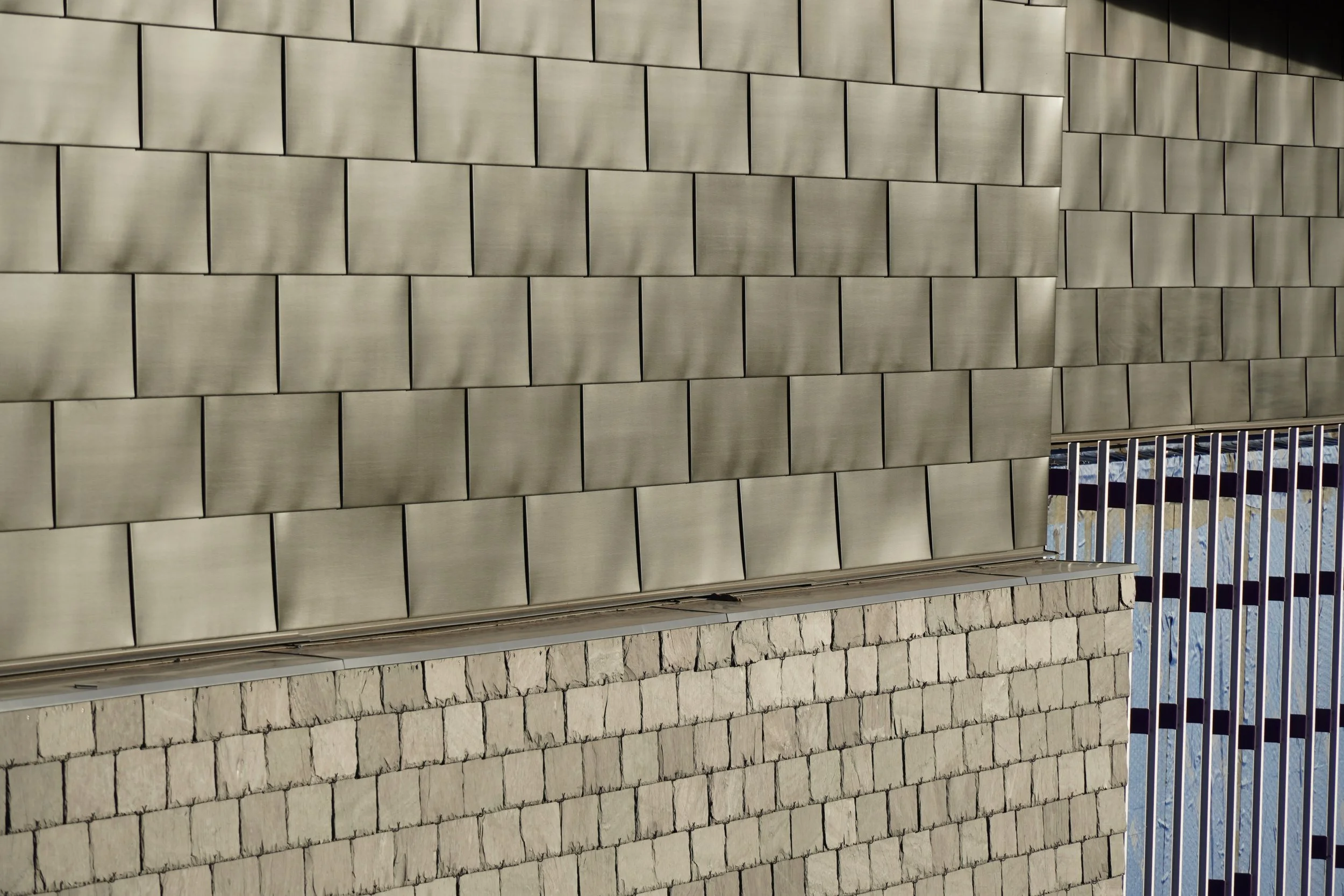 Slate, metal panel, and masonry siding convergence at Gianforte Hall demonstrating design and construction management.