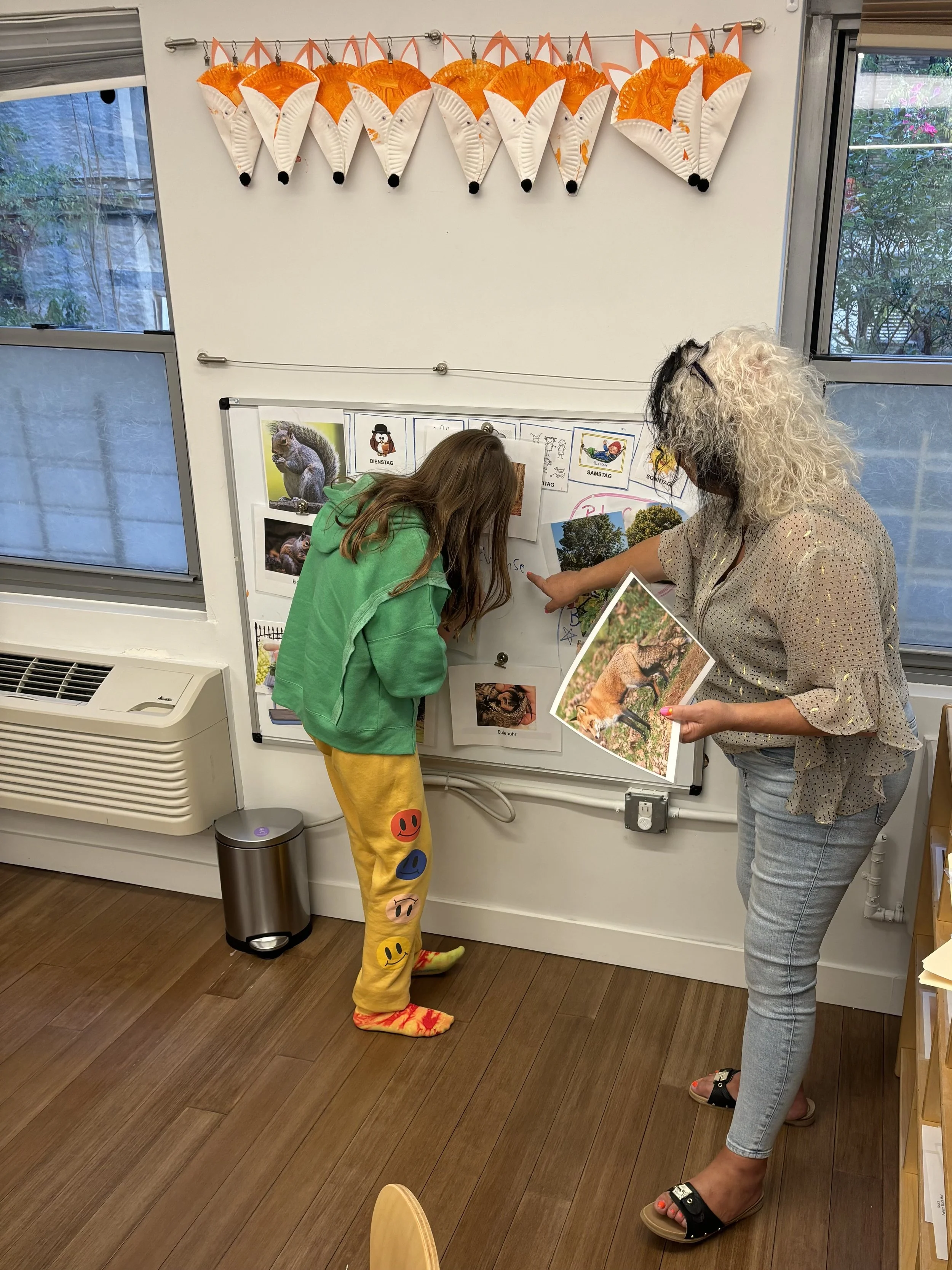 German language learning: student and teacher on a white board, writing and explaining