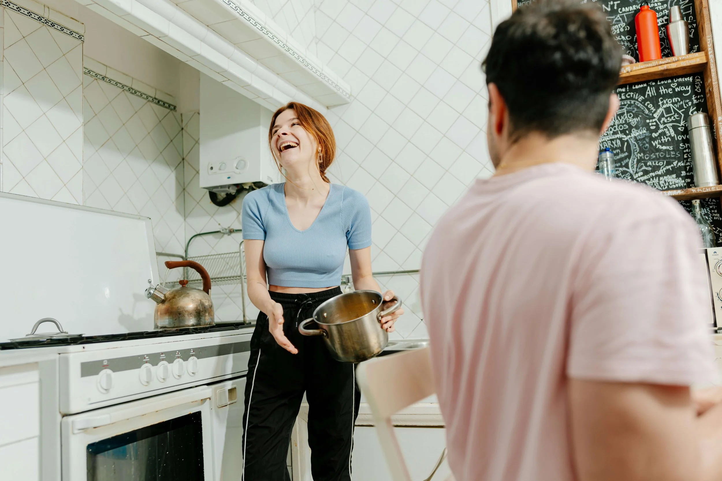 Couple laughs together in a white kitchen