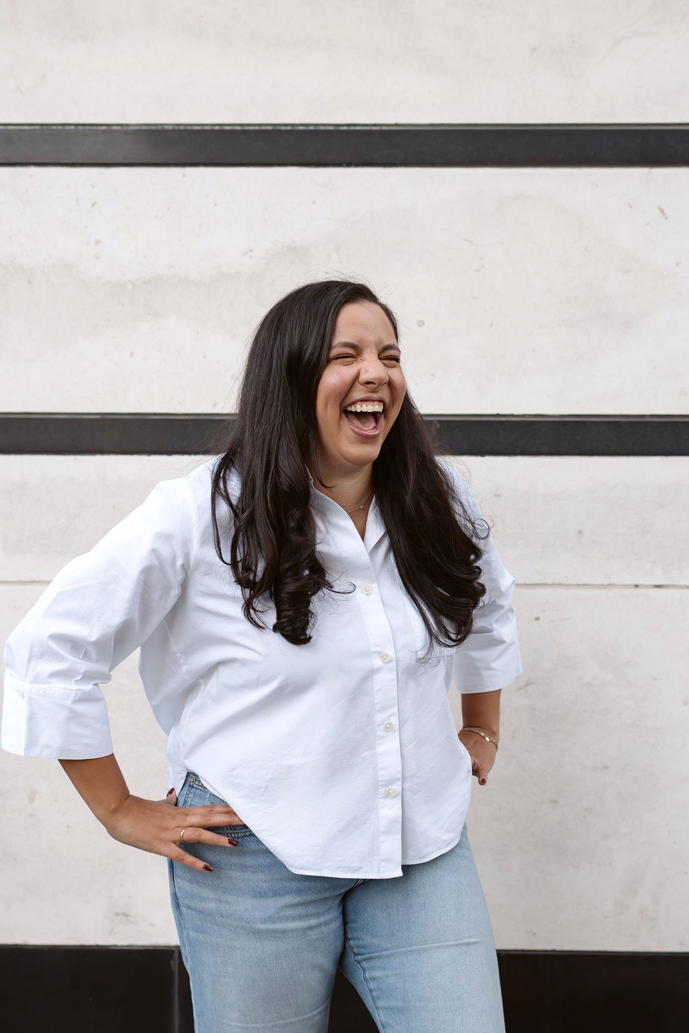 Jessica laughs with hands on her hips