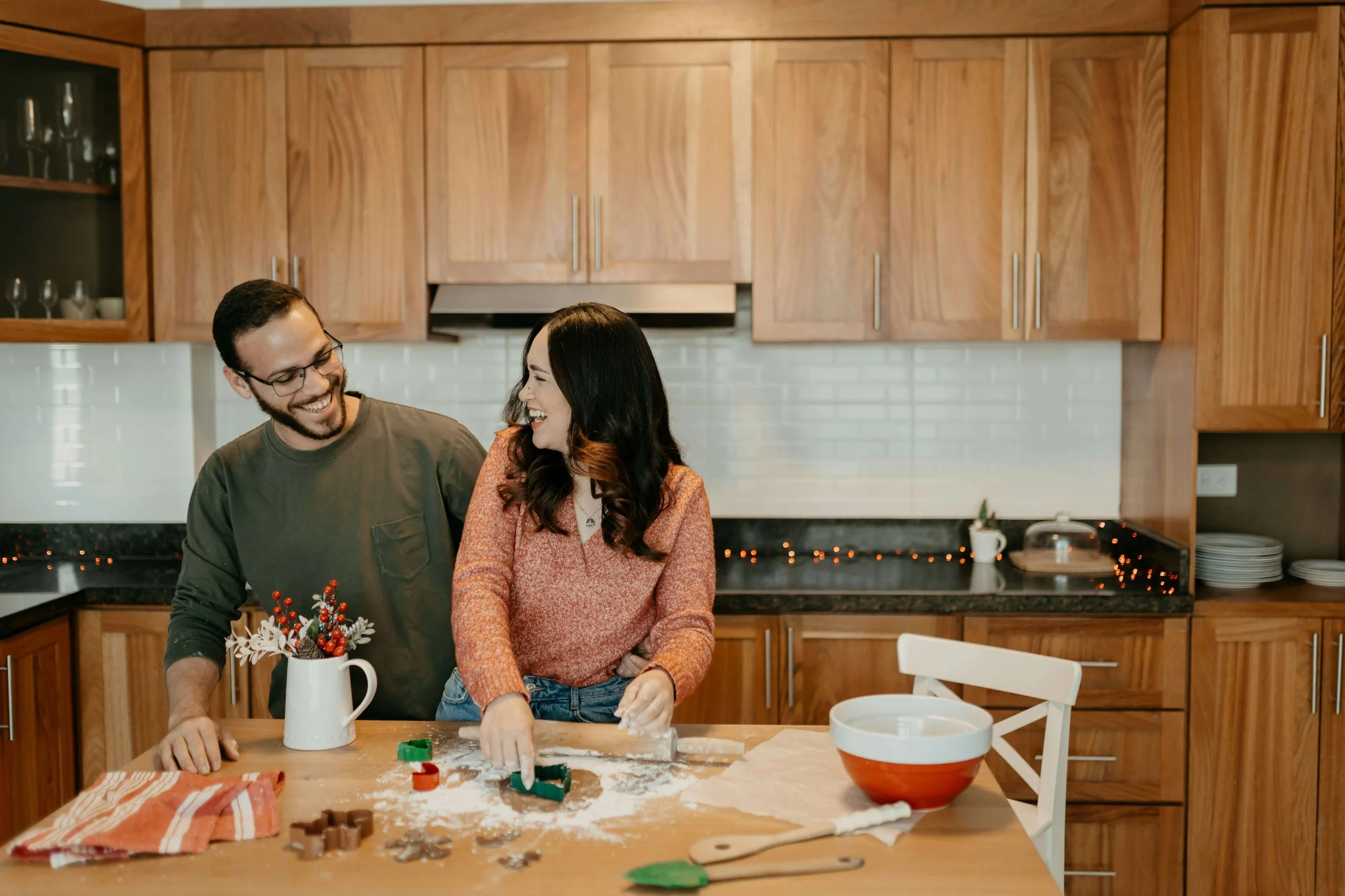 A man and a woman smile to each other while baking