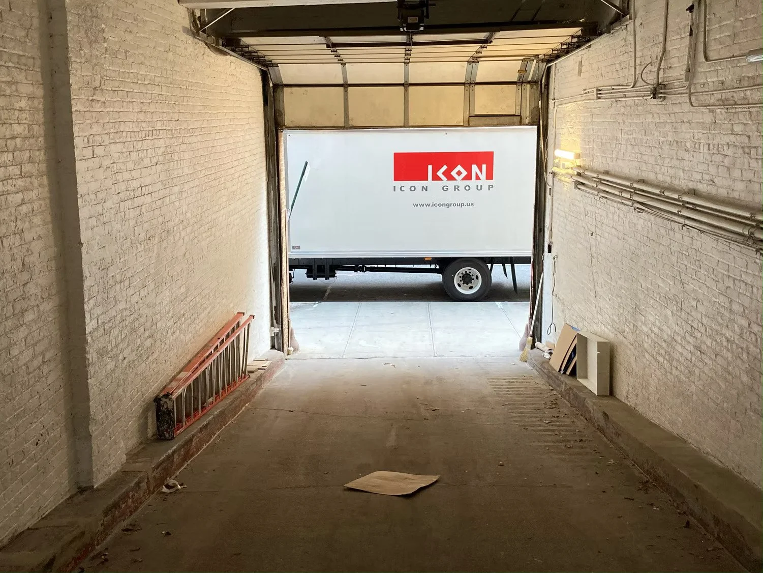 View of a garage with a truck outside displaying the logo of ICON Art Services.