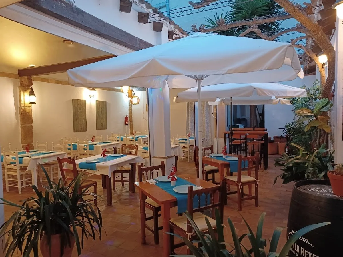 Wood tables with parasols at the garden terrace of La Comanda&Cia restaurant in Dénia