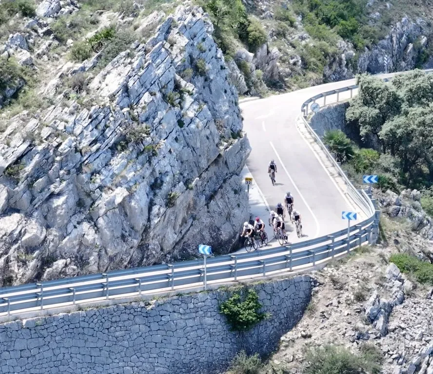 Bike riders decending a curvy road in the mountains