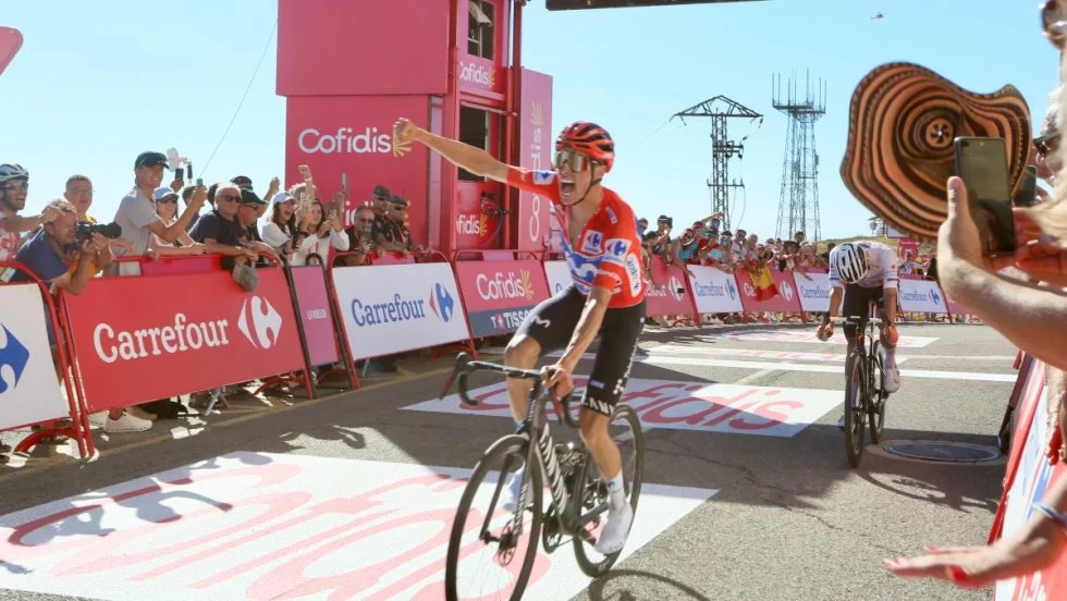 A professional cyclist rejoices after crossing the finish line at Aitana mountain first