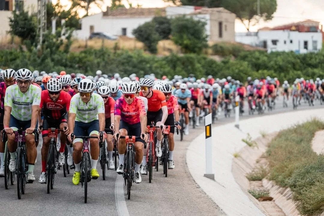 A large group of cyclists many in similar uniforms participating in a race