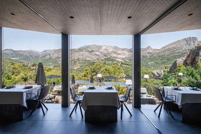 Tables at Panoramic restaurant at VIVOOD Hotel with a forest and montains in the background