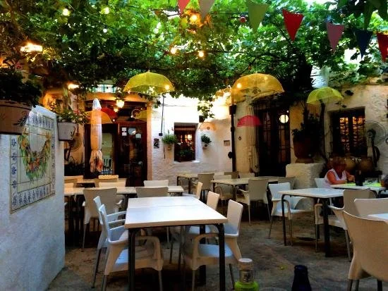 Tables and chairs in the garden terrace of L'Om restaurant in Pego