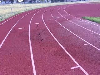 Empty red running track with white lane markings