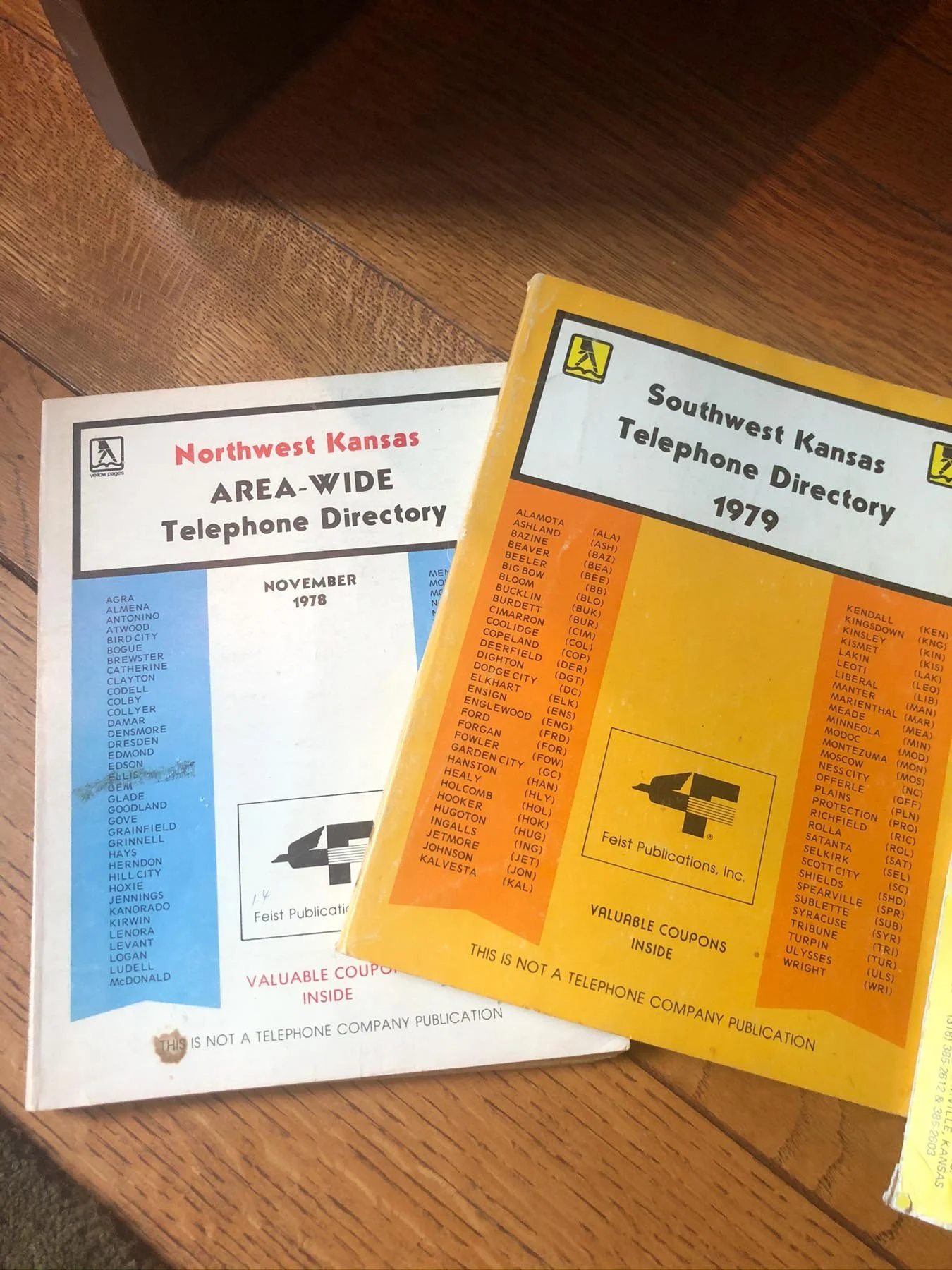 Two vintage telephone directories, one for Northwest Kansas and one for Southwest Kansas, dated from 1978 and 1979 respectively, placed on a wooden surface.