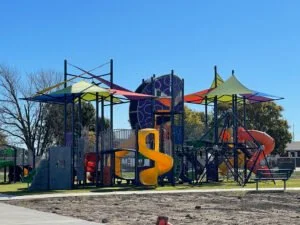 Colorful playground structure with slides and climbing areas under a clear blue sky