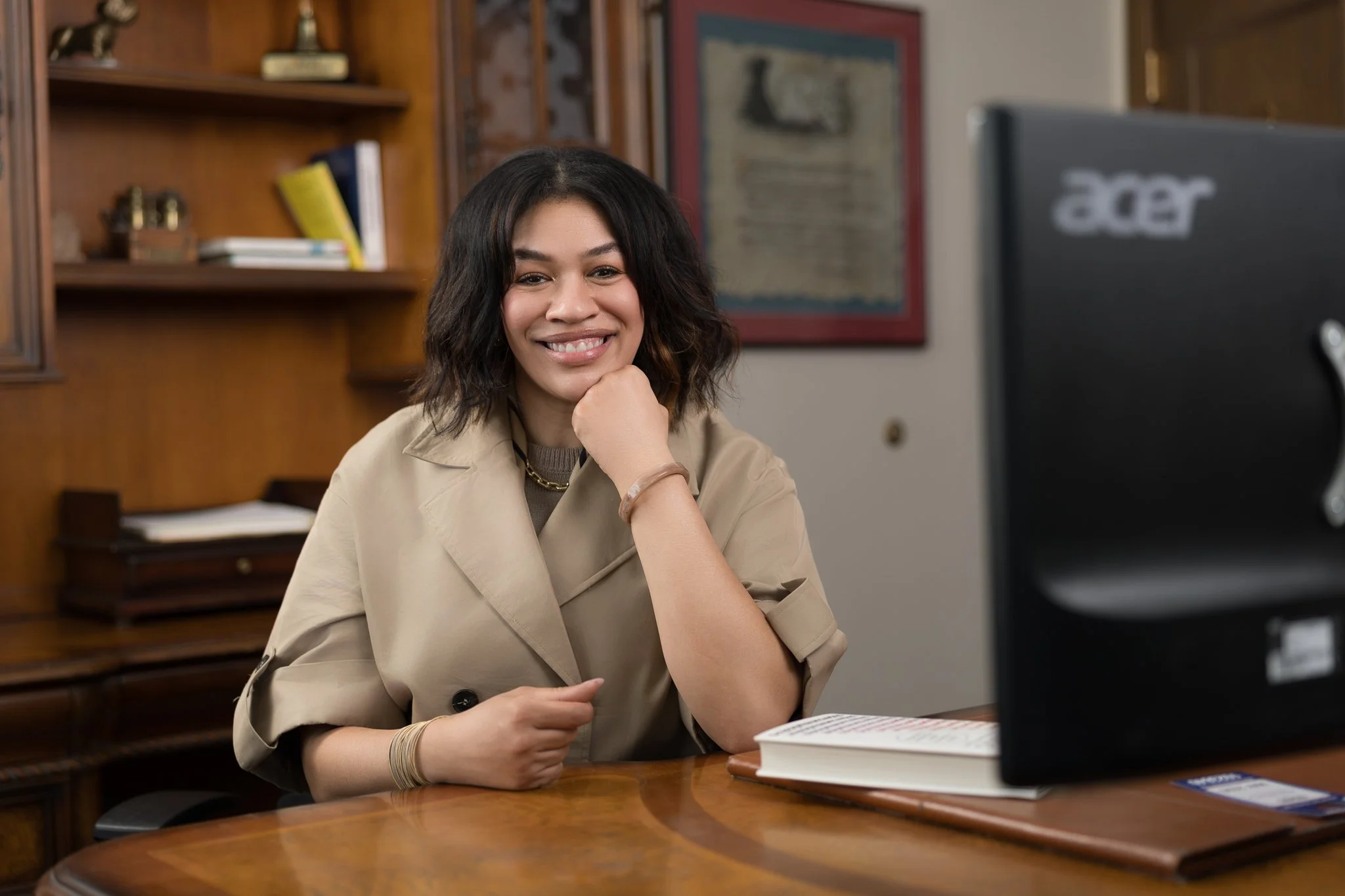 Woman sitting at desk with chin on hand and book in front of her