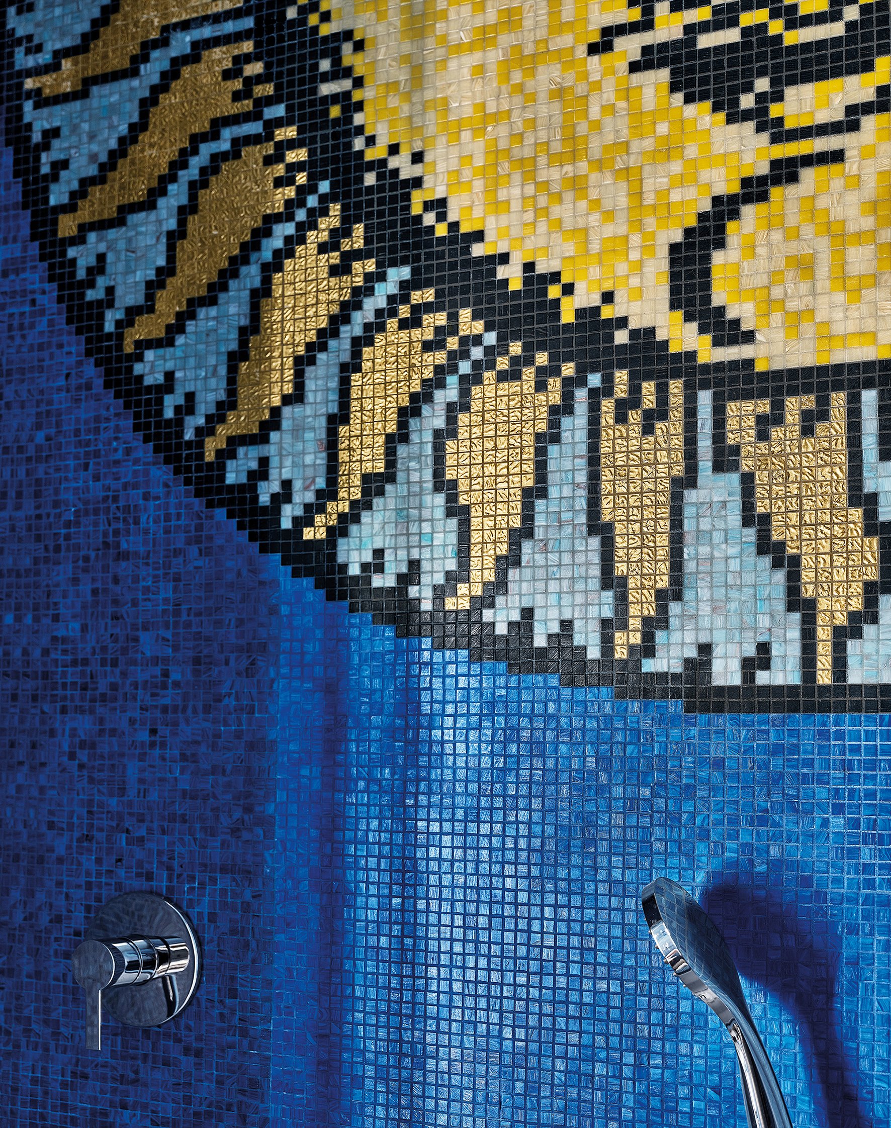 Detalle de mural de azulejos en colores azul, negro, oro y blanco con diseño geométrico.