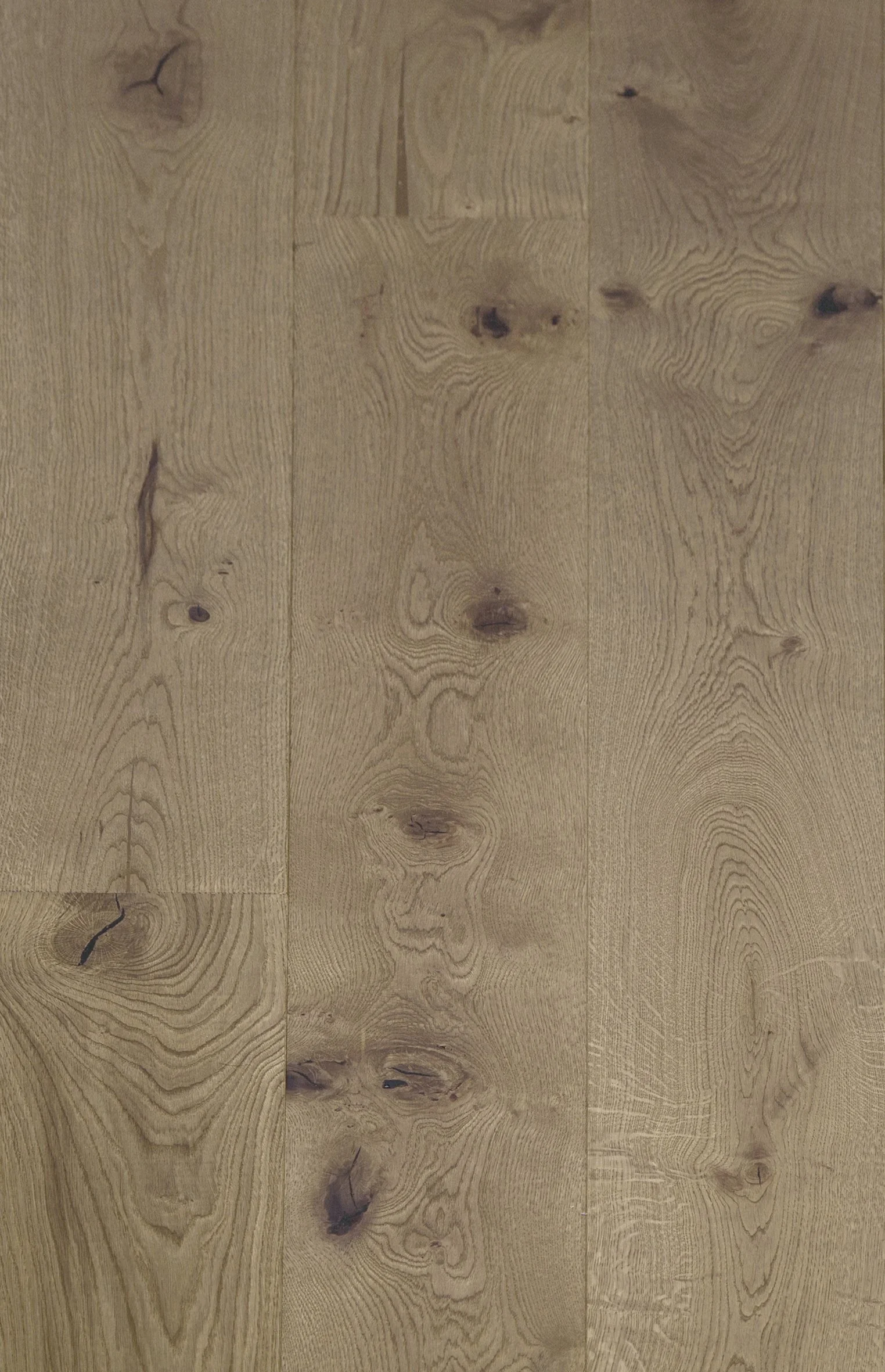 Vista de un piso de madera con vetas y nudos en tonos marrón claro.