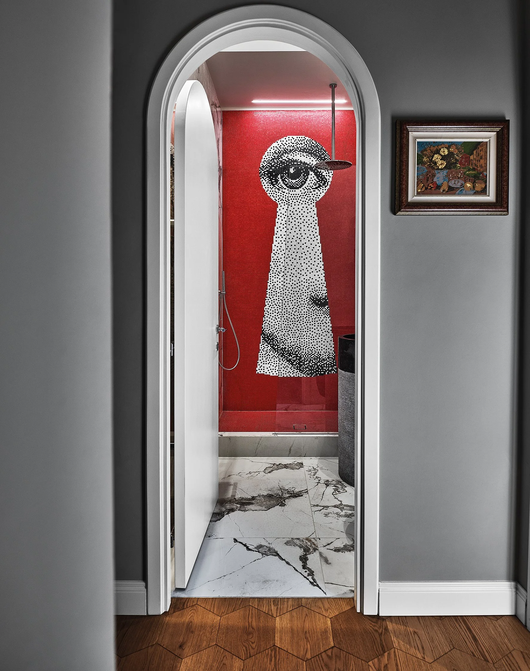 Vista de un vestidor con mosaico de una figura de un perro en la pared de fondo, rodeada de paredes grises y piso de mármol.