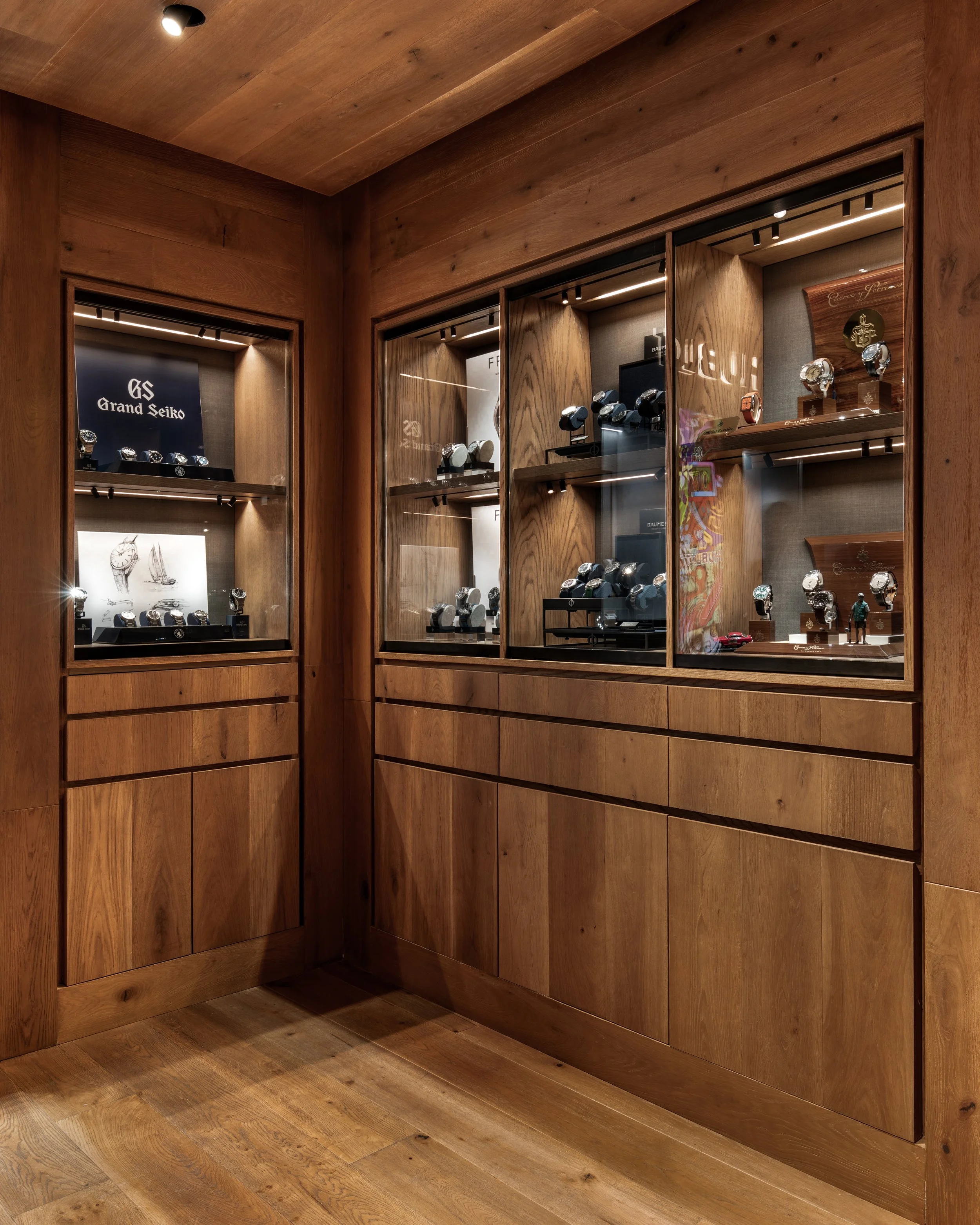 Vitrina de madera con relojes de lujo en exhibición.