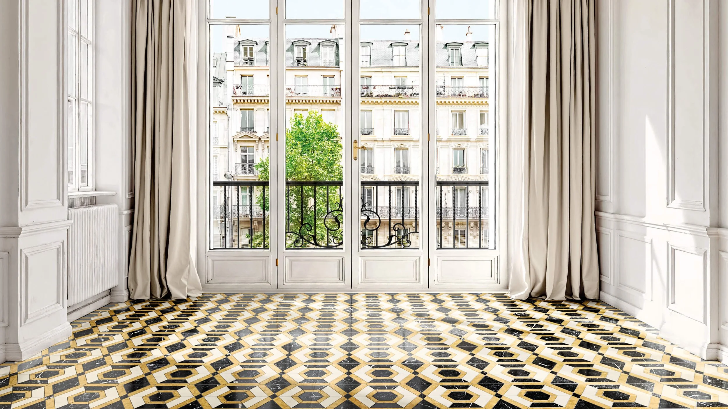 Habitación con ventanas grandes, cortinas blancas y piso de azulejos en patrón geométrico en colores beige, negro y gris.