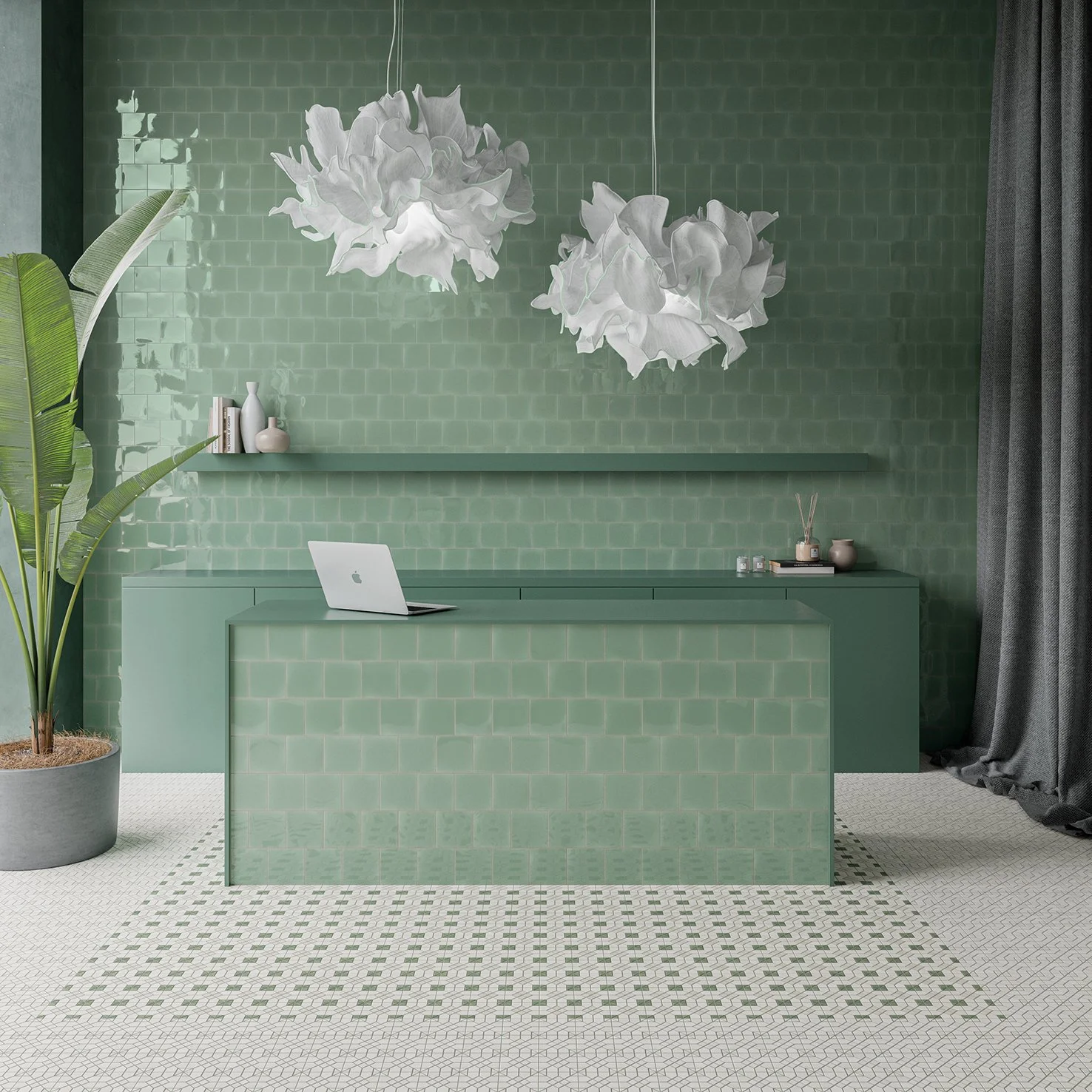Interior de oficina decorada en tonos verdes con pizarra de azulejos verdes en la pared, maceta con planta grande, lámparas colgantes con aspecto de papel y una mesa de recepción con computadora portátil y artículos decorativos.