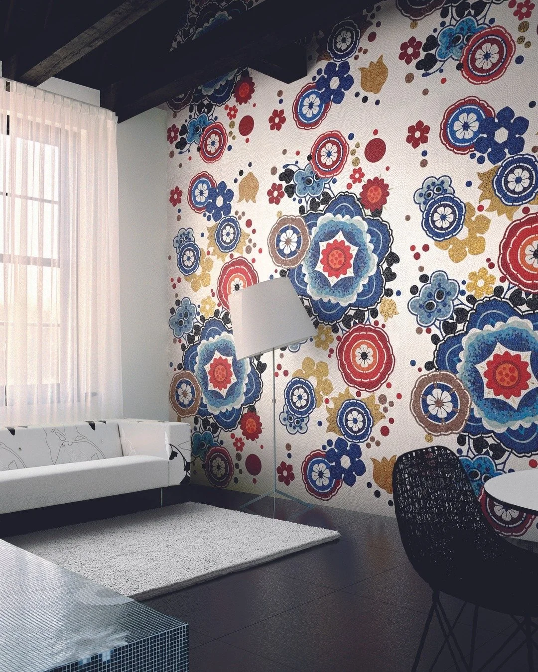 Salón con pared decorada con un moisaco de patrones florales en colores azul, rojo, dorado y negro, con cortinas blancas, sofá blanco, alfombra beige y una lámpara de pie blanca.