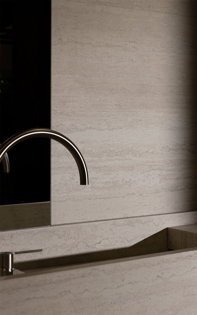 Imagen de una encimera de cocina de piedra clara con un fregadero y un grifo de acero inoxidable.