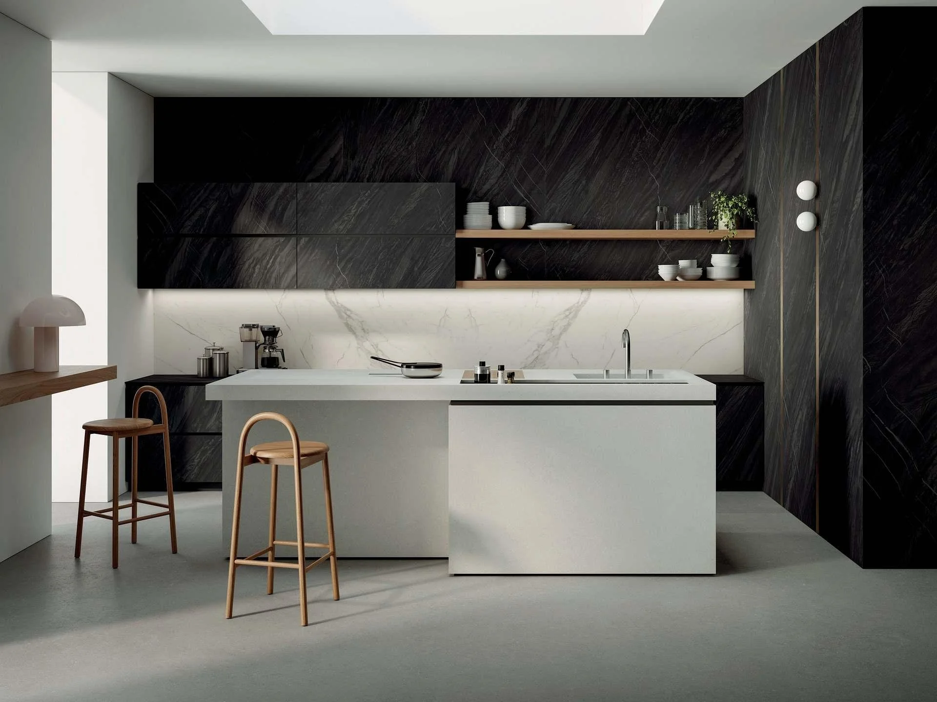 Cocina moderna con mueble negro, encimera blanca, estantes abiertos con vajilla y decoraciones, paredes de mármol, sillas de madera